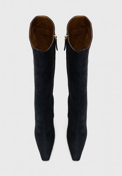 Fekete velúr térdig érő csizma hegyes orral és sima textúrával, oldalán cipzárokkal és barna belső béléssel.