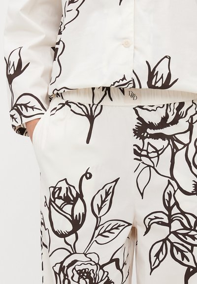 Set de cămașă și pantaloni cu imprimeu floral în crem cu contururi negre. Prezintă o croială lejeră, talie elastică și accente cu nasturi pe cămașă.