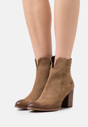 Wildleder-Stiefeletten in Hellbraun mit runder Spitze und Blockabsatz. Verfügt über elastische Seitenpaneele und dezente dekorative Nähte.