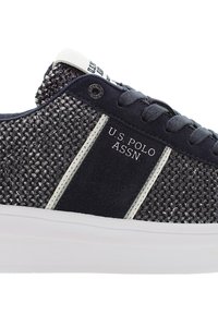 Mörkblå sneakers med en texturerad mesh-ovandel och mockadetaljer; har vita ränder och U.S. Polo Assn. logotyp på sidan.
