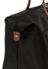 Borsa nera in nylon con dettagli in pelle marrone, dotata di chiusura con zip, forma rettangolare e dettaglio a scatto in metallo sul lato.