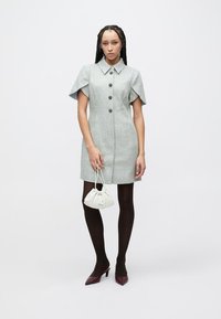 Button-up dress in light gray herringbone pattern, short sleeves with a collar, paired with a white fabric bag and dark brown tights.