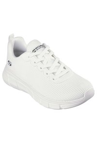 Zapatilla deportiva blanca hecha de material de malla transpirable con parte superior texturizada, cierre con cordones y suela de goma acolchada. Presenta un logo.