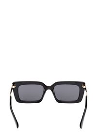 Sorte rektangulære solbriller med tykke rammer og mørke linser, prydet med guldstykker på hængslerne og tempelarmene.
