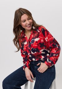 Rode en meerkleurige bloempatronen blouse met een kraag en een relaxed fit, voorzien van lange mouwen met elastische boorden.