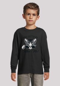 Schwarzes Langarmshirt mit einem cartoonhaften Kater, der eine Sonnenbrille trägt, und dem Text "DU MUSST MICH VERARSCHEN!" darüber gedruckt.