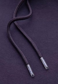 Cordon de sweat à capuche violet foncé avec un design texturé et tressé, et embouts en plastique transparent affichant un logo en relief.