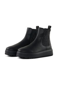 Bottines noires en cuir texturé, avec des panneaux élastiques sur les côtés et une semelle en caoutchouc épaisse avec un motif de crampons.