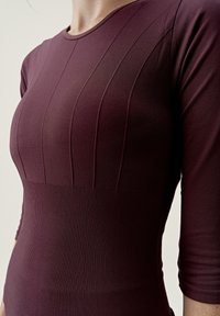 Bordowy dopasowany top z prążkowaną fakturą, z pionowym panelem i rękawami o długości do połowy przedramienia, z gładkim wykończeniem.