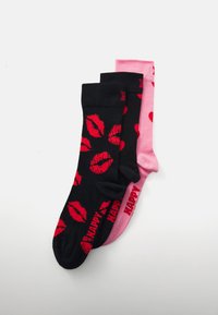 Trois paires de chaussettes en coton : une noire avec des lèvres rouges, une noire avec des cœurs rouges, et une rose avec des cœurs rouges. Toutes présentent des bords côtelés.