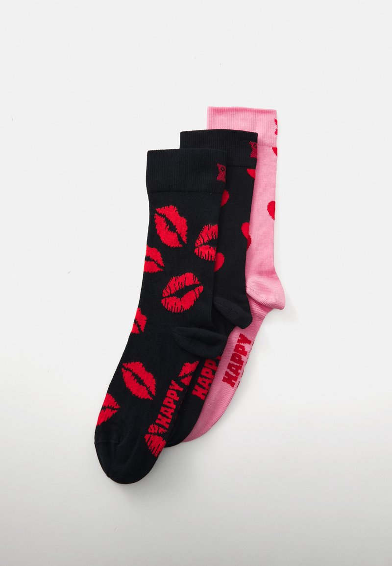 Trois paires de chaussettes en coton : une noire avec des lèvres rouges, une noire avec des cœurs rouges, et une rose avec des cœurs rouges. Toutes présentent des bords côtelés.