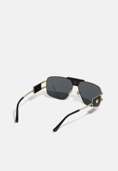 Gafas de sol rectangulares con lentes grises, montura de metal dorado, acentos negros y un detalle de hardware distintivo en las patillas.