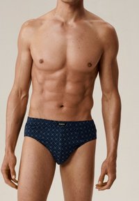 Granatowe kąpielówki z wzorem diamentowym, wykonane z elastycznego materiału. Posiadają markowy pas i dopasowany krój.