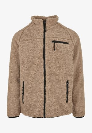 Jachetă din fleece bej cu guler înalt, cu fermoar pe față și trei buzunare cu fermoar. Suprafață texturizată cu fermoare și accente negre.