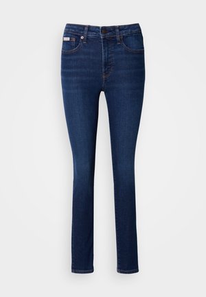 Donkerblauwe denim jeans met een slim fit. Voorzien van vijf zakken, een knoop- en ritssluiting, en contrasterende stikdetails.