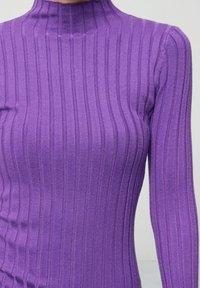 Pull violet à côtes avec un col haut et des manches longues. Le tissu a une texture lisse, avec des rayures verticales sur l'ensemble.