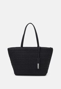 Czarna pleciona torba typu tote o wyraźnie zarysowanym, kanciastym kształcie. Posiada dwa solidne uchwyty oraz metkę z logo DKNY. Wykonana z teksturowanego materiału.