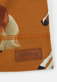 Tecido castanho com ilustrações de cavalos, costura texturizada e uma etiqueta de pele castanha em relevo com a inscrição "walkiddy."