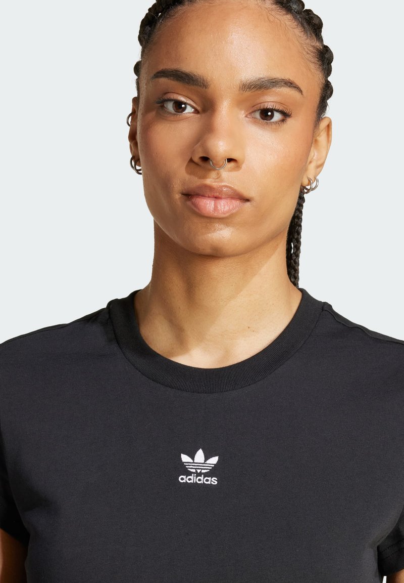 Schwarzes Baumwoll-T-Shirt mit Rundhalsausschnitt und kurzen Ärmeln. Mit weißem, auf die Brust gesticktem Adidas-Logo. Glatte Textur.