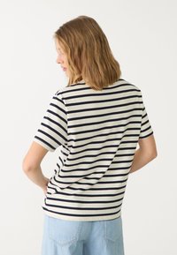 Kortærmet T-shirt i creme med navy vandret striber, med rund hals og afslappet pasform, lavet af blødt bomuldsstof.