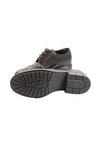 Scarpe in pelle nera con dettagli in pizzo, accenti brogue e suola in gomma con motivo. Il design presenta una finitura liscia e punta arrotondata.