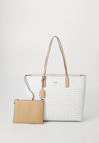 Balta rankinė su DKNY logotipo raštu, smėlio spalvos odinės rankenos ir atskiriama pouches, turinti lygią tekstūrą ir stačiakampį forma.