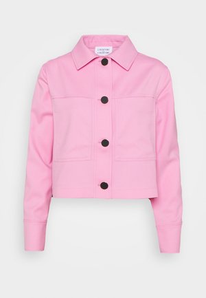 Veste courte rose clair à manches longues, boutons noirs sur le devant, deux poches poitrine et col pointu.