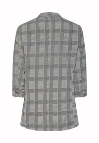 Randig blazer i svart och vitt tyg, med slagkrage, trekvartsärmar och en lös passform med rak ryggdesign.