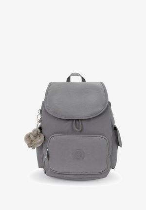 Gray fabric backpack with front zipper pocket, side pockets, top flap closure, and a small plush monkey keychain attached.