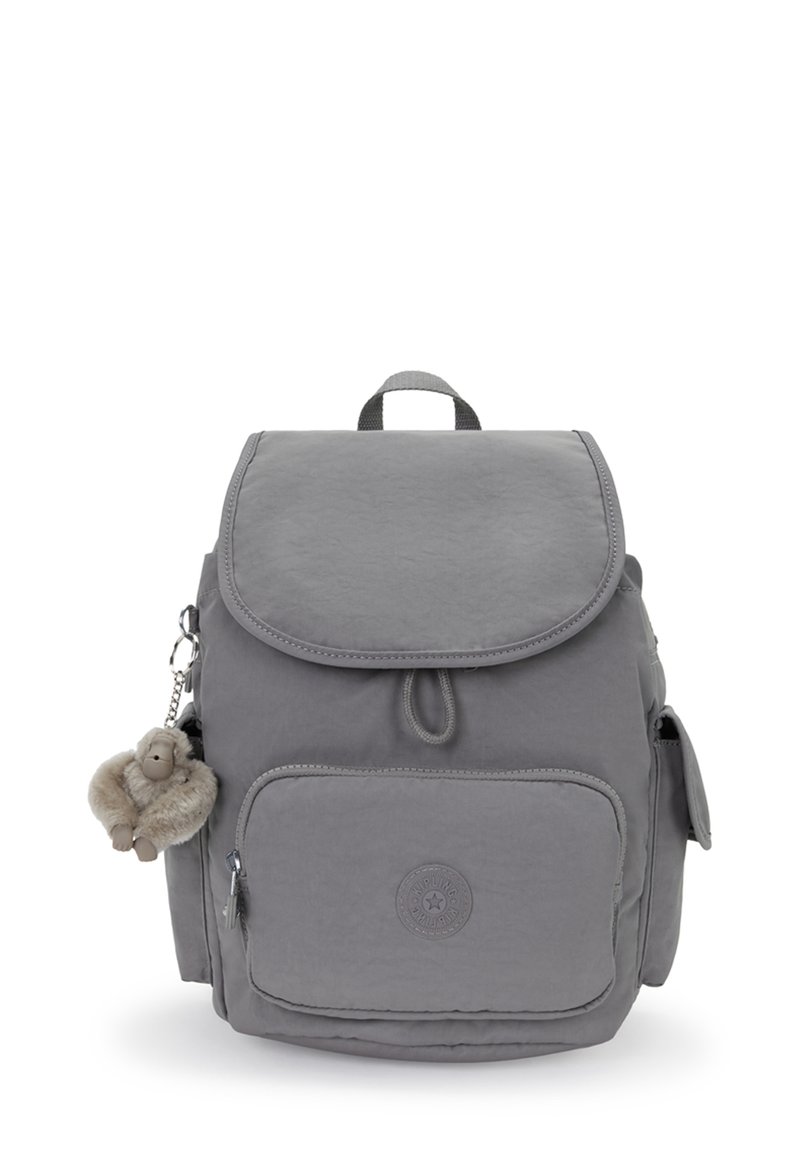 Sac à dos en tissu gris avec poche zippée à l'avant, poches latérales, fermeture à rabat supérieur et un petit porte-clés en peluche de singe attaché.