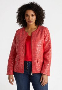 Röd paljettjacka med rundad halsringning, dragkedja fram och två frontfickor. Texturerad yta med glänsande paljetter, ihop med en röd topp.