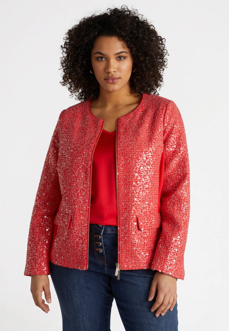 Röd paljettjacka med rundad halsringning, dragkedja fram och två frontfickor. Texturerad yta med glänsande paljetter, ihop med en röd topp.