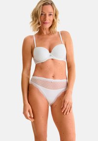 Witte lingerieset met een gepadded beha met een gladde textuur en subtiele stippenpatroon, gecombineerd met bijpassende doorschijnende slipjes met kantafwerking.