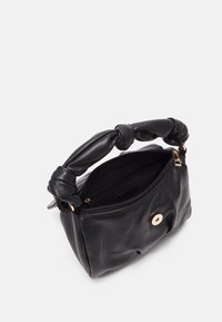 Mustassa nahkakäsilaukussa on solmittu kahva, vetoketjukiinnitys ja kultasävyinen nappi edessä. Suloinen pinta, kompakti muotoilu.