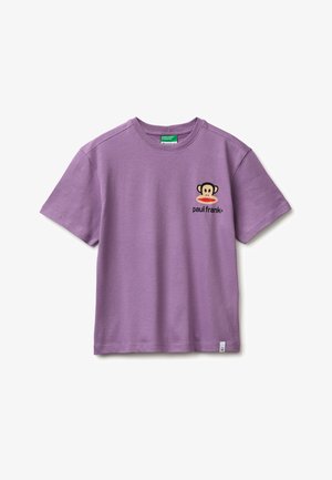 Camiseta de manga corta color lavanda con cuello redondo, pequeño logo de mono de Paul Frank y texto en el pecho izquierdo, etiqueta interior verde y pequeña etiqueta en el dobladillo.
