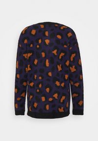 Lila tröja med svart och orange leopardtryck, tillverkad av mjukt, texturerat material, med en rundad halsringning och långa ärmar.