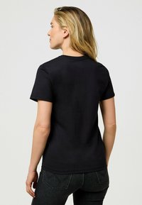 Sort bomulds t-shirt med korte ærmer, rund halsudskæring og glat tekstur, vist fra ryggen med minimal syning.