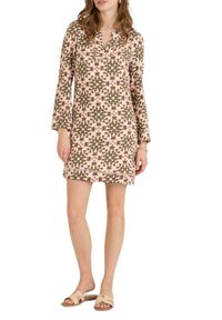 Vestido de estampado floral en rosa, verde y marrón, con mangas largas, escote en V y corte recto. Combinado con sandalias neutras.