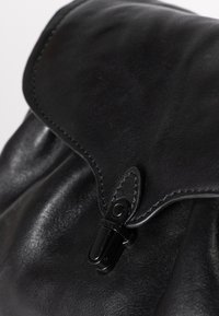 Borsa in pelle nera con finitura testurizzata, dotata di chiusura a patta e di un bottone a scatto nero. Design liscio ed elegante.