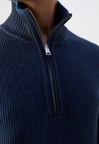 Maglione in maglia coste blu navy con collo alto e chiusura con mezza cerniera, caratterizzato da un motivo testurizzato e da una cerniera in metallo argento.