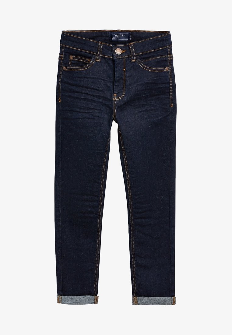 Jean slim ajusté bleu foncé avec revers roulés, bouton avant, fermeture éclair et coutures contrastantes orange.