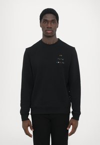 Čierna mikina so širokým golierom a rebrovanými manžetami a lemom, na hrudi s farebným vyšitým logom "PS PAUL SMITH". Hladká textúra tkaniny.