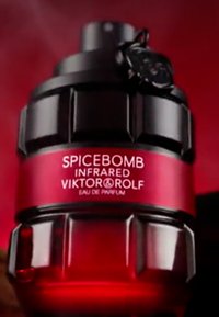 Flacon de parfum noir et rouge avec un design ressemblant à une grenade. L'étiquette indique "SPICEBOMB INFRARED VIKTOR & ROLF EAU DE PARFUM." Accents noirs et surface texturée.