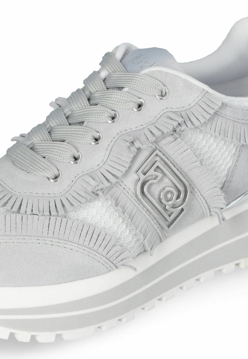 Grau Sneakers aus Wildleder, Netzstoff und Fransenverzierung, mit metallischen Ösen und einem Logoakzent an der Seite. Dicke weiße Sohle.