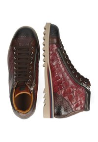 Wysokie trampki z teksturowaną, brązowo-czerwoną skórzaną cholewką, metalowym zamkiem błyskawicznym i gumową podeszwą z kontrastującą, paskowaną krawędzią.