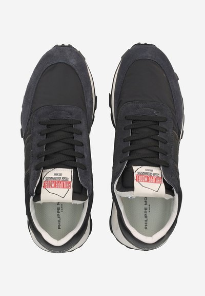 Scarpe da ginnastica nere in suede e nylon con accenti bianchi, lacci rotondi, colletto imbottito e etichette con logo sulla linguetta. Suola in gomma con battistrada testurizzato.