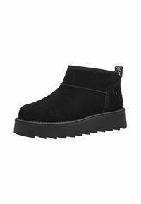 Botines de ante negro con suela de cuña, punta redondeada y una distintiva suela con zigzag. Presentan una lengüeta para facilitar el calzado y un detalle de costura en contraste.