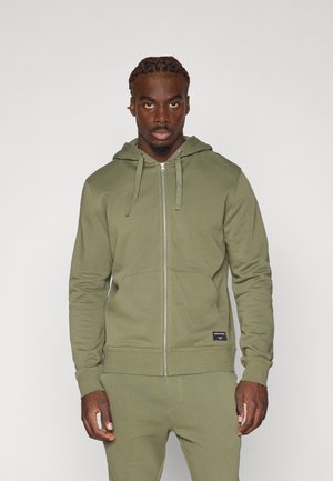 Olive green zip-up hoodie made of soft material, featuring a front pocket, hood with drawstrings, and ribbed cuffs and hem.