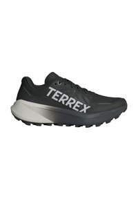Crne trkačke tenisice s mrežastim gornjim dijelom, velikim bijelim logotipom "TERREX" i gradijentnom sivom međupodlogom. Imaju teksturiranu površinu i potplat s gripom.
