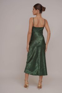 Πράσινο σατέν φόρεμα με λεπτές τιράντες και μέτριο μήκος. Διαθέτει υφή και διακριτή γυαλάδα. Ορατή λεπτομέρεια με φερμουάρ στην πλάτη.